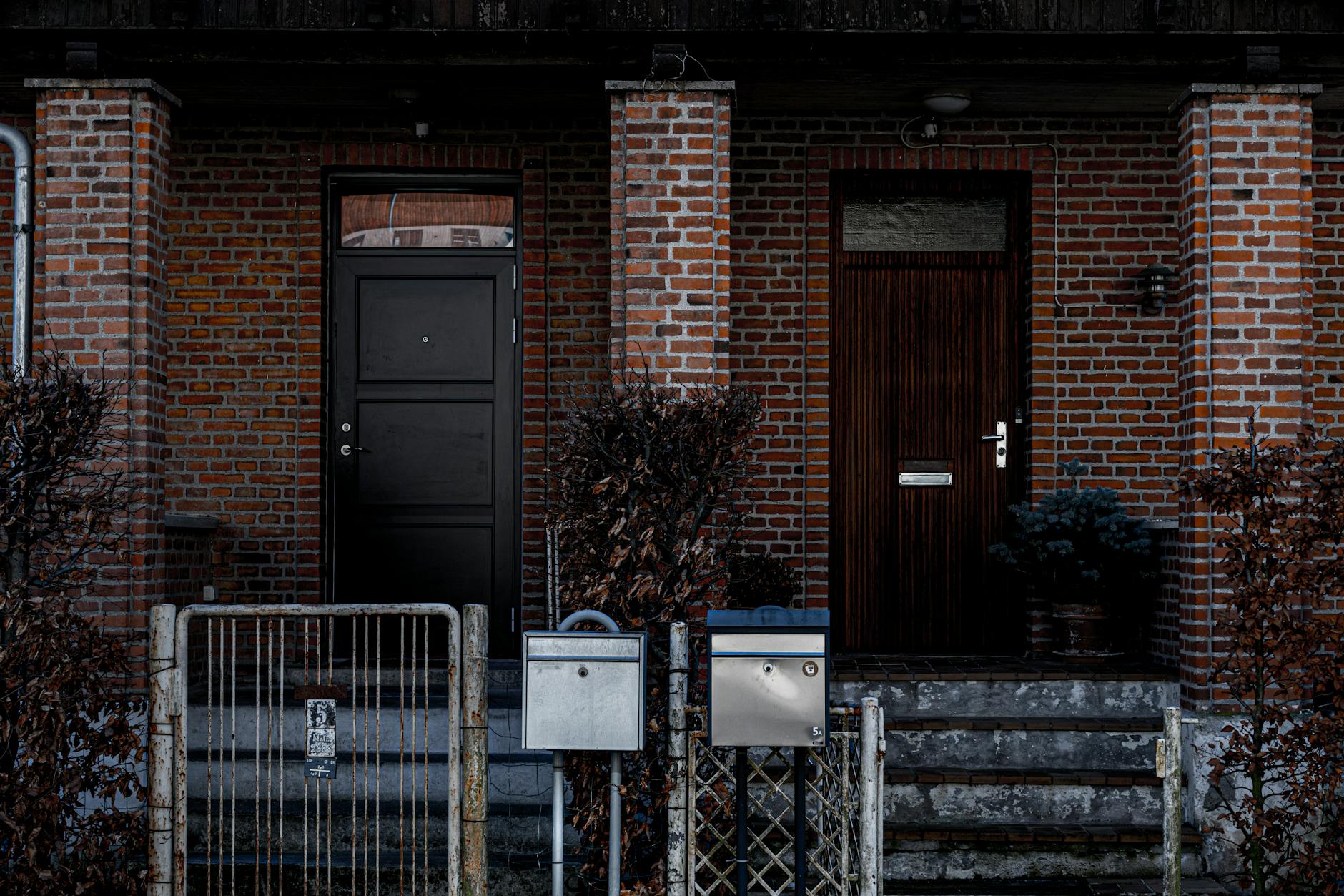 Ceglana fasada domu z dwojgiem różnych drzwi wejściowych